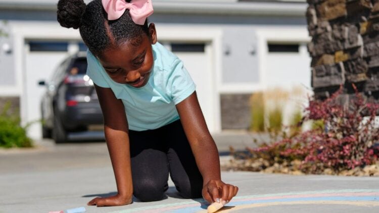 a child drawing on the sidewalk